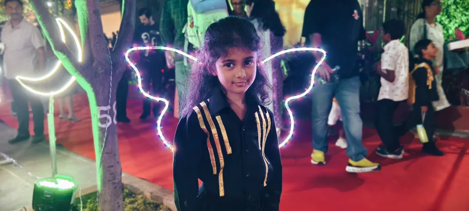 Siya standing with glowing fairy wings at an event