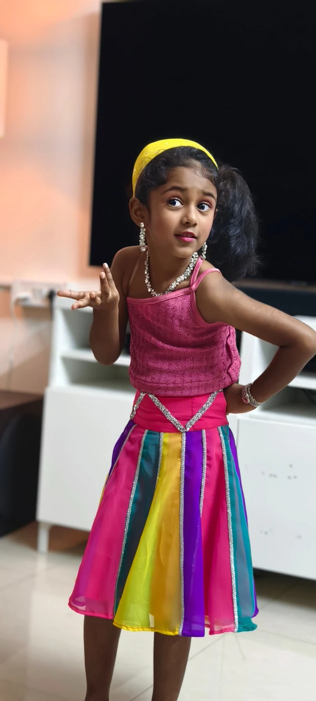 Siya posing in a bright rainbow dress